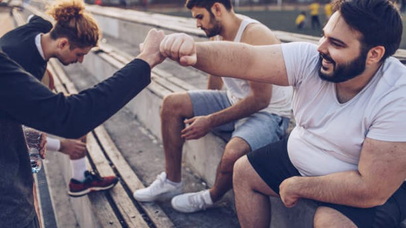 A healthy man having a conversation with his overweight friend to help them get fit
