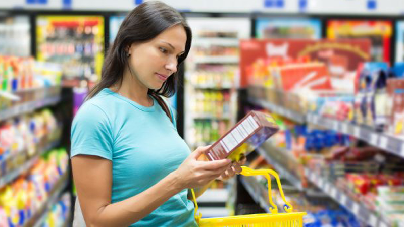 A fit woman and her overweight friend reading the labels when grocery shopping