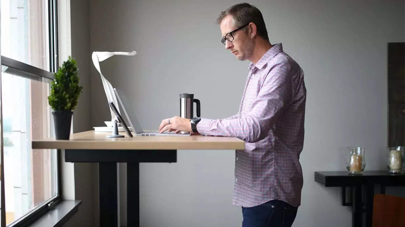 an office worker using a standing desk to support his weight loss efforts