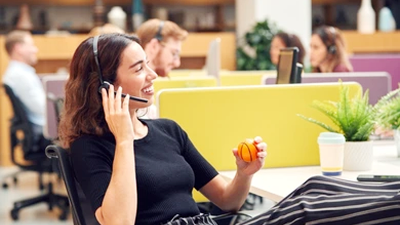 woman using a stress ball while talking on the phone